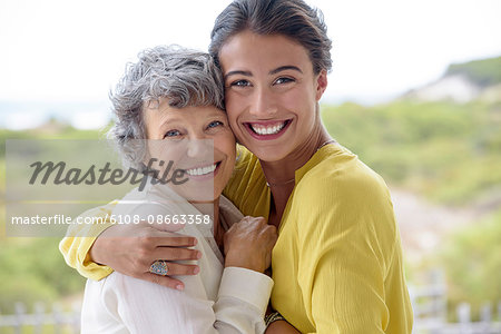 Happy mother hugging her adult daughter outdoors