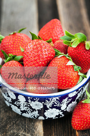 Fresh organic ripe strawberry in a bowl on wooden table