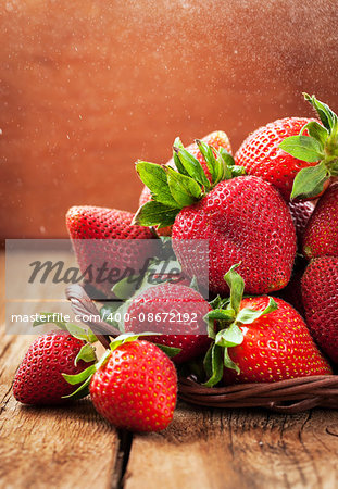 Fresh organic ripe wet strawberry on wooden table with water splash around