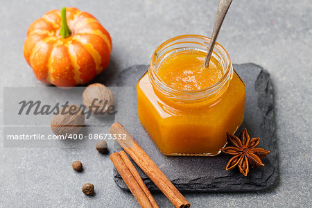 Pumpkin confiture, jam, sauce with spices on stone table.