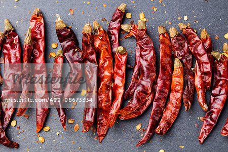 Dried red chili peppers on slate background Top view Copy space.