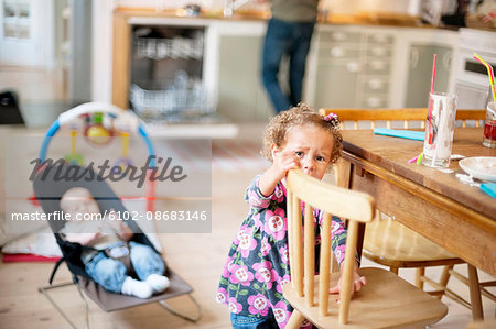 Girl standing by chair