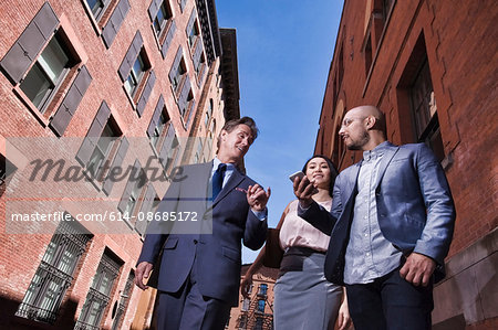 Businessmen and women walking outdoors, low angle view
