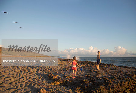 Girl and brother playing on beach, Blowing Rocks Preserve, Jupiter Island, Florida, USA