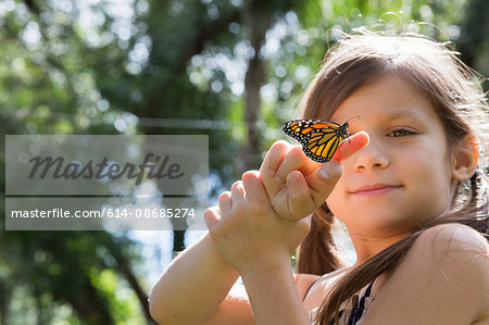 Girl holding monarch butterfly on finger