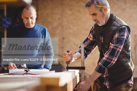 Carpenter fixing a plank of wood in carpentry