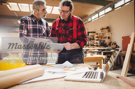 Carpenters using a tablet computer in carpentry