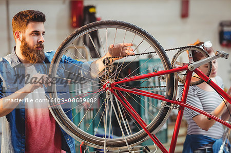 Colleague repairing a bicycle in a workshop