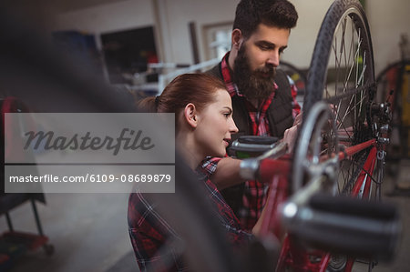 Mechanics repairing a bicycle in workshop