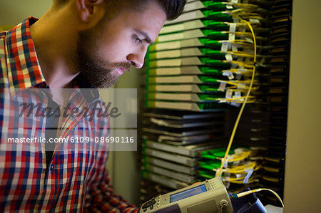 Close-Up of technician using digital cable analyzer in server room