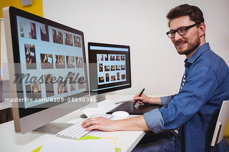 Portrait of male photo editor working on computer in creative office
