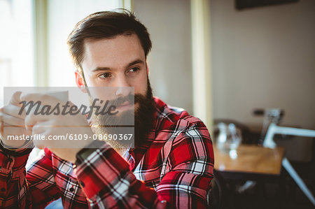 Thoughtful customer sitting with coffee at cafe
