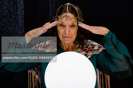 Mature fortune teller with crystal ball