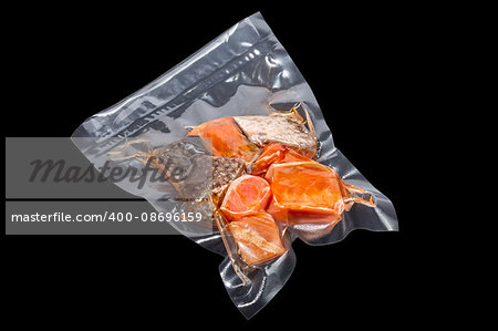 vacuum packaged pieces of salmon on the black background