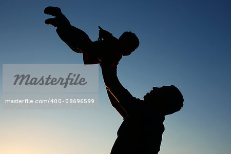 silhouette of father and son play