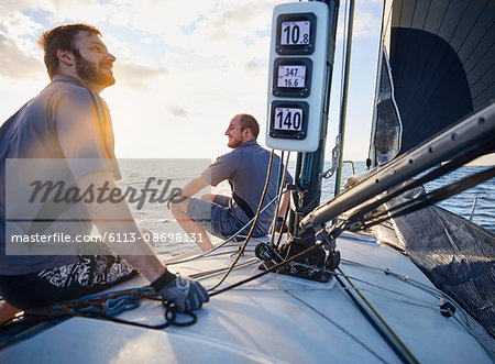 Men monitoring wind on sailboat