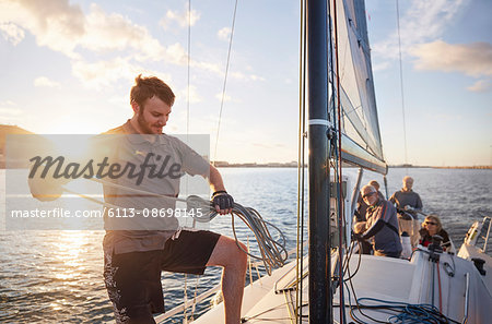 Man sailing looping rigging on sailboat