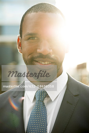 Businessman backlit by sun, portrait