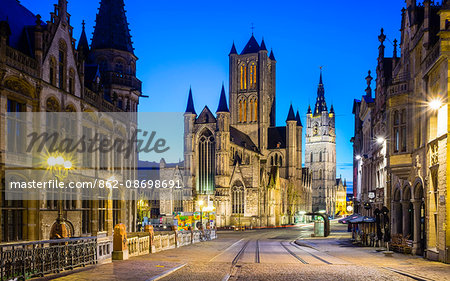 Belgium, Flanders, Ghent (Gent). Sint-Niklaaskerk (Saint Nicholas' Church) and Het Belfort van Gent, 14th century belfry, at night from St. Michael's Bridge.