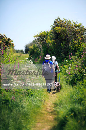 England, Cornwall, Isles of Scilly. Two people walking dogs on St Marys island.