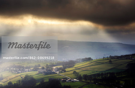 England, West Yorkshire, Calderdale. Sunlight shining through clouds onto mills and houses near Halifax. England, West Yorkshire, Calderdale. Sunlight shining through clouds onto mills and houses near Halifax.