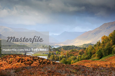 Scotland, Glen Affric. Person enjoying the view towards Loch Affric and mountains of Kintail. MR.