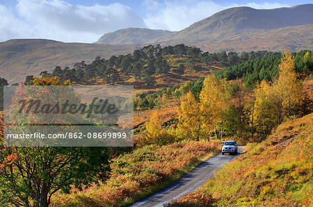 Scotland, Glen Lyon. A car driving through the Glen in autumn.
