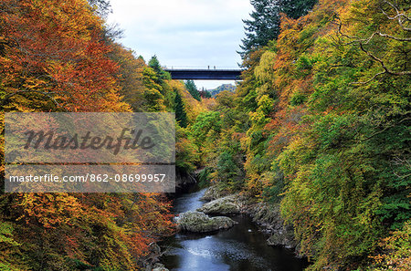 Scotland, Pitlochry. People on the bridge over the River Garry in autumn, near the Pass of Killiecrankie.