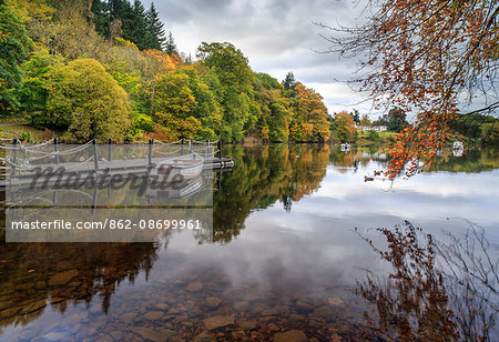 Scotland, Pitlochry. Small jetty and boat on the River Tummel in autumn.
