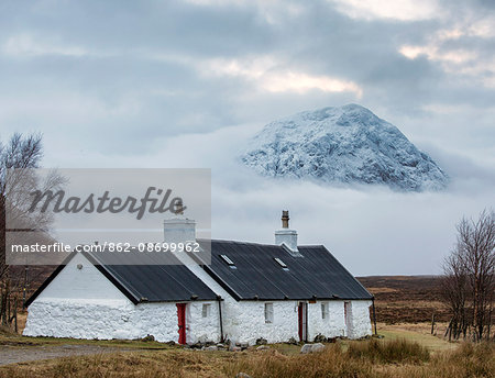 Scotland, Rannoch Moor. Black Rock cottage with Buachaille Etive Mor behind, rising above the fog.