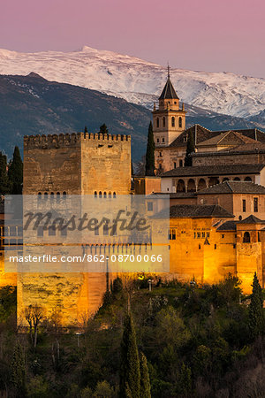 View at dusk of Alhambra palace with the snowy Sierra Nevada in the background, Granada, Andalusia, Spain