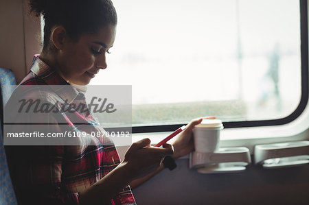 Young woman using phone while sitting in train