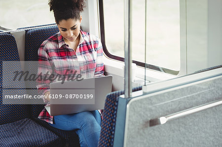 Woman with laptop while sitting in train