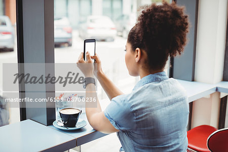 Woman using phone while siting at restaurant