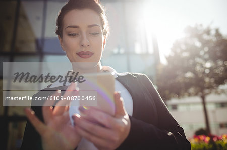 Young businesswoman using mobile phone on sunny day