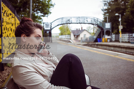 Beautiful woman talking on phone at railroad station