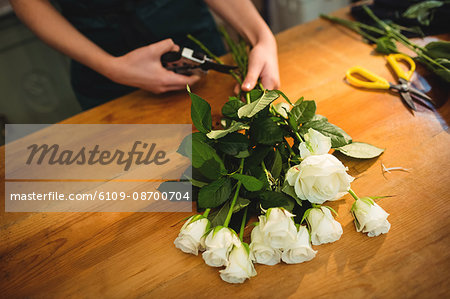 Close-up of female florist trimming flower stem at her flower shop