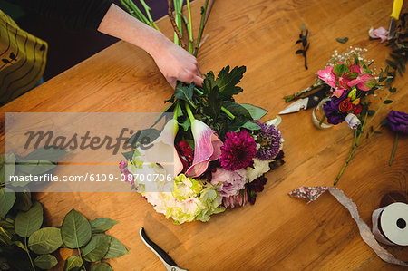 Close-up of female florist preparing a flower bouquet at her flower shop