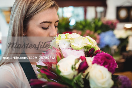 Female florist smelling flower bouquet at her flower shop