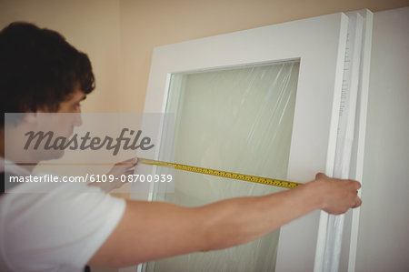 Carpenter measuring a door at home