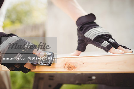 Close-up of carpenter\'s hand sharpening chisel on stone