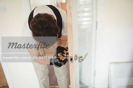 Carpenter fixing door lock at home