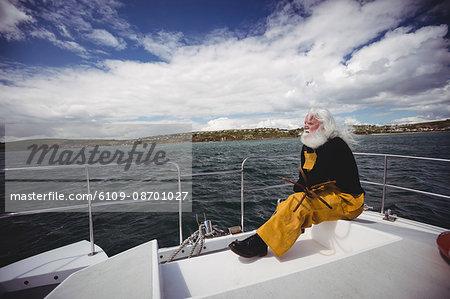 Thoughtful fisherman sitting on fishing boat