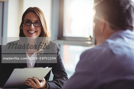 Portrait of businesswoman holding clipboard in office