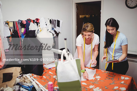 Female fashion designer working on tablet in the studio