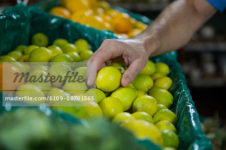 Close-up of man holding lemon in supermarket