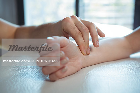 Therapist checking patient pulse in clinic