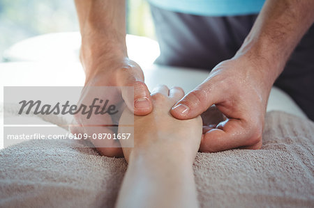 Male physiotherapist giving hand massage to female patient in clinic