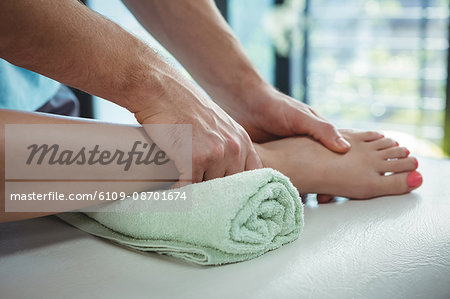 Close-up of physiotherapist giving physical therapy to the leg of a female patient in the clinic