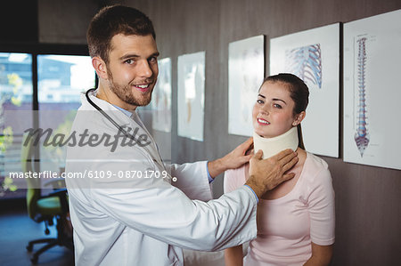 Portrait of physiotherapist examining a female patient's neck in the clinic